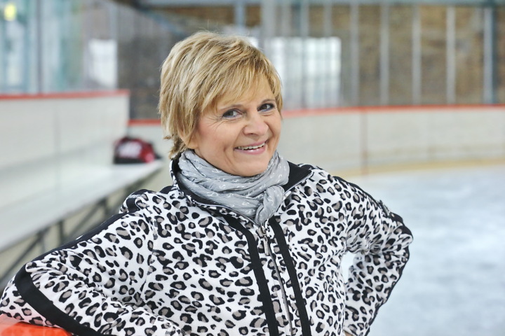 Christine Stüber-Errat lächelt in gemusterter Jacke vor einer Eisfläche.